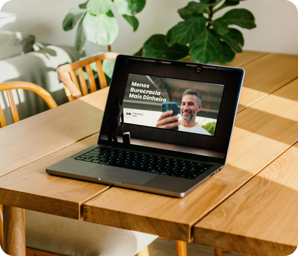 Laptop exibindo vídeo "Menos Burocracia Mais Dinheiro" sobre o LCbank